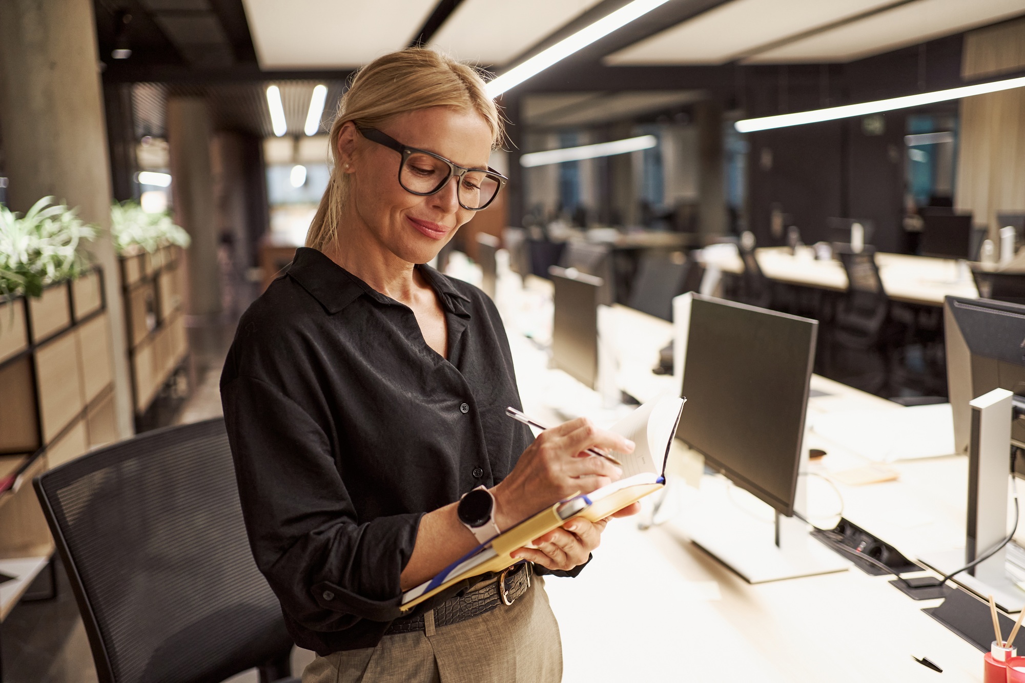 A Professional Woman Engaging in Writing Tasks Within a Contemporary Office Environment